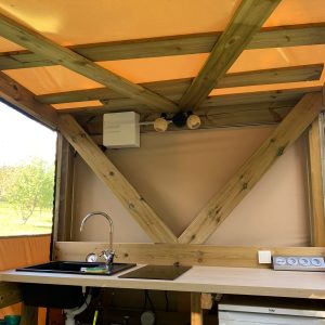 Cuisine dun hébergement insolite en bois à Limousin, avec éclairage chaleureux.