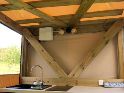 Cuisine dun hébergement insolite en bois à Limousin, avec éclairage chaleureux.