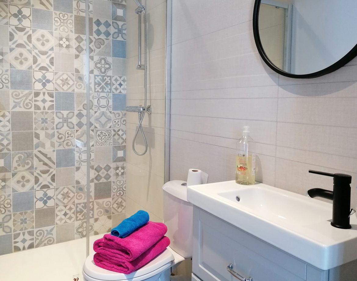 Salle de bain moderne dun hébergement insolite en Auvergne-Rhône-Alpes, avec carrelage décoratif.