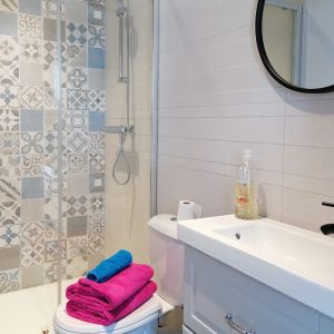 Salle de bain moderne dun hébergement insolite en Auvergne-Rhône-Alpes, avec carrelage décoratif.