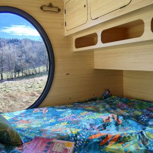 Hébergement insolite en bulle avec vue panoramique sur la nature et literie colorée.