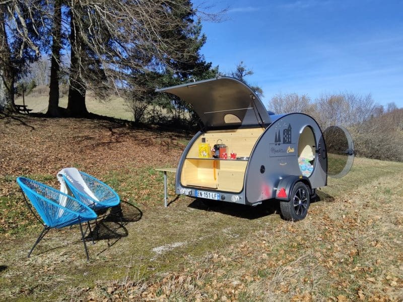 Hébergement insolite : une caravane vintage avec un coin salon en plein air.