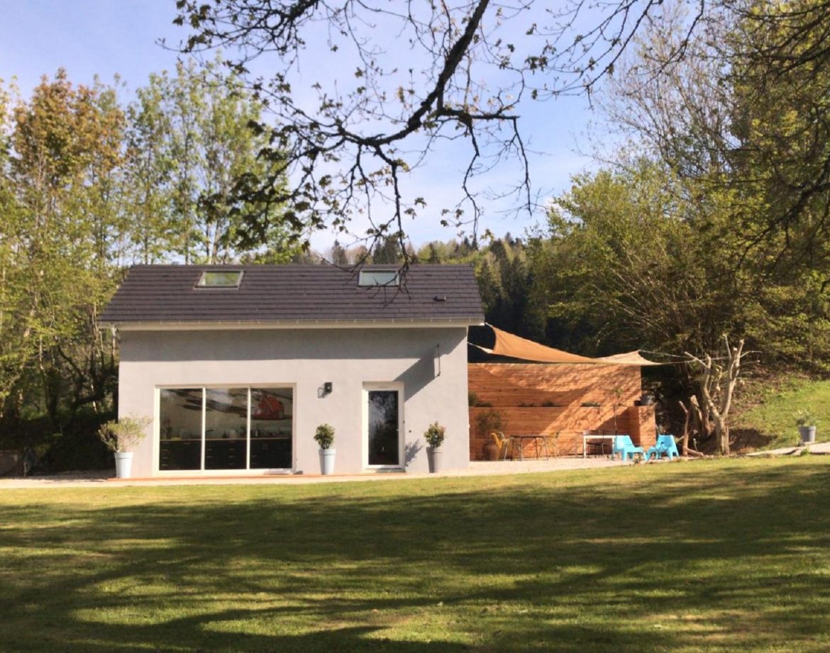 Hébergement insolite en Auvergne-Rhône-Alpes, maison moderne avec terrasse en bois.