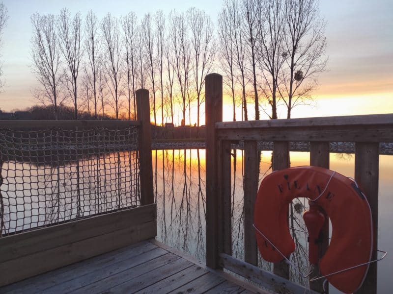 Hébergement en bord de lac, avec un coucher de soleil et une bouée orange.