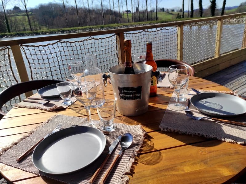 Table en bois avec champagne, vue sur la rivière, hébergement en bord de leau.