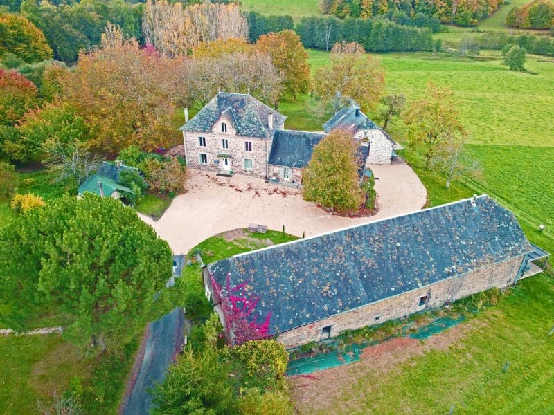 Charmante maison de campagne entourée darbres colorés et de verdure.