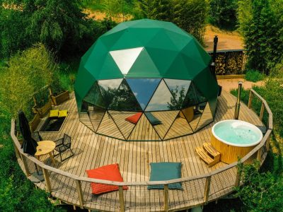 Dôme géodésique en Auvergne avec terrasse en bois et jacuzzi extérieur.