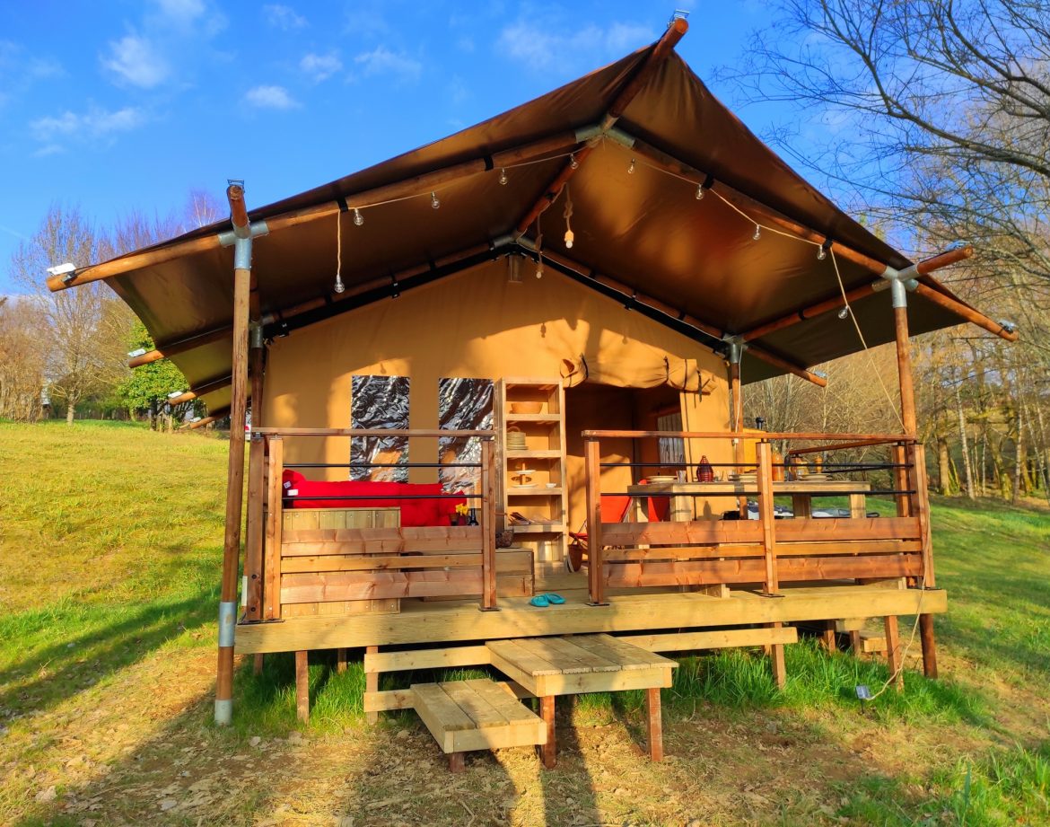 Cabane en toile à Limousin, avec terrasse en bois et vue sur la nature environnante.
