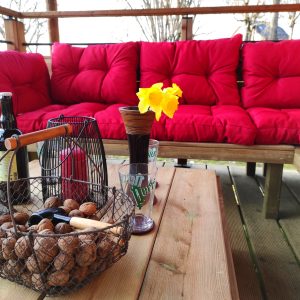Hébergement insolite à Limousin : salon extérieur avec coussins rouges et décor chaleureux.