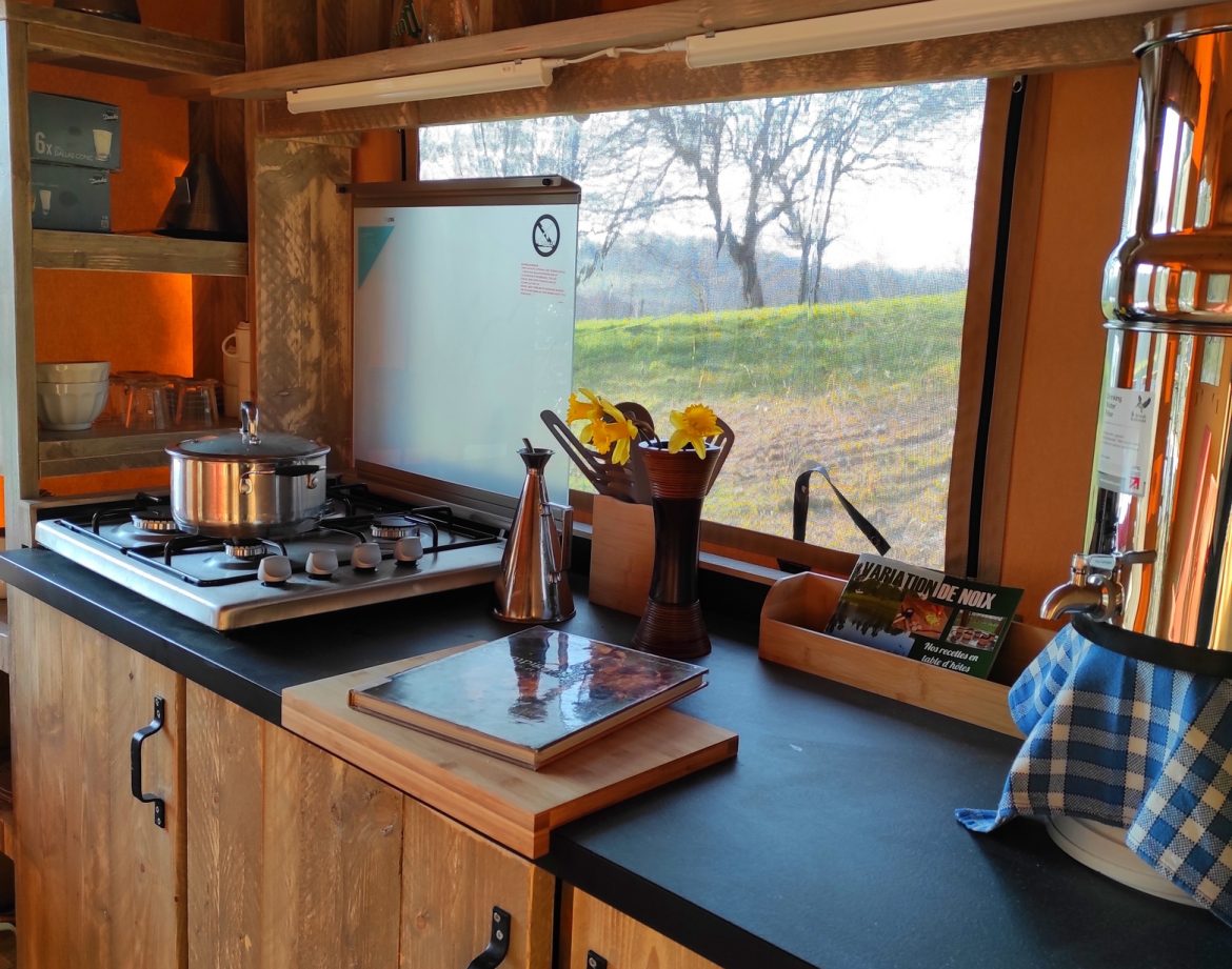 Hébergement insolite à Limousin : cuisine moderne en bois avec vue sur la nature.