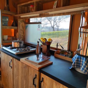 Hébergement insolite à Limousin : cuisine moderne en bois avec vue sur la nature.