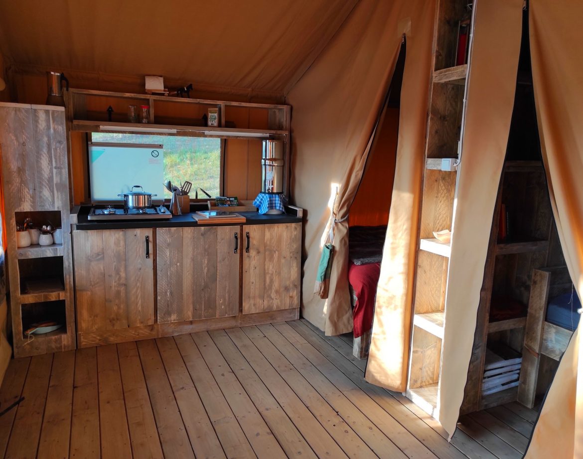 Tente safari moderne à Limousin, avec cuisine en bois et lit douillet.
