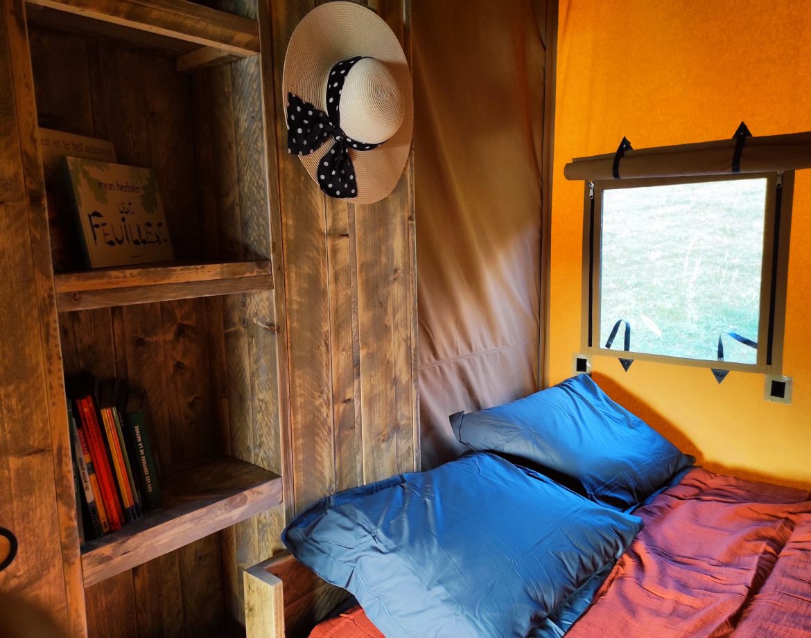 Cabane insolite à Limousin, avec des coussins moelleux et une étagère en bois.