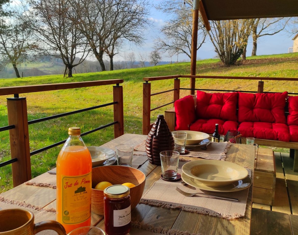 Hébergement insolite en Limousin : terrasse en bois avec vue sur la nature et mobilier confortable.