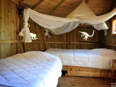 Cabane en bois cosy avec lits confortables et décor naturel apaisant.