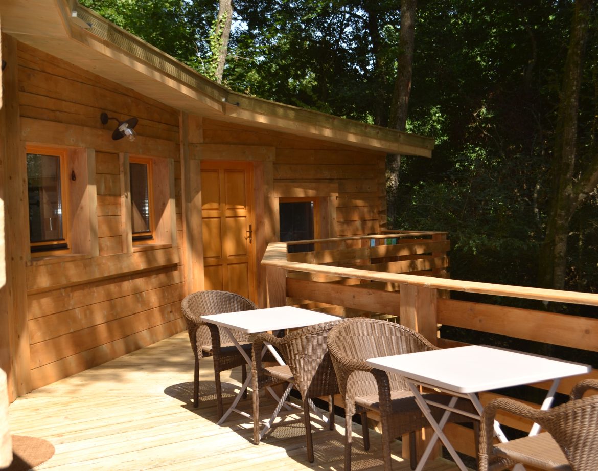 Cabane en bois en Nouvelle-Aquitaine avec terrasse et mobilier extérieur.