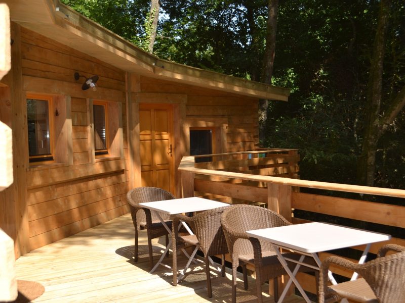 Cabane en bois en Nouvelle-Aquitaine avec terrasse et mobilier extérieur.