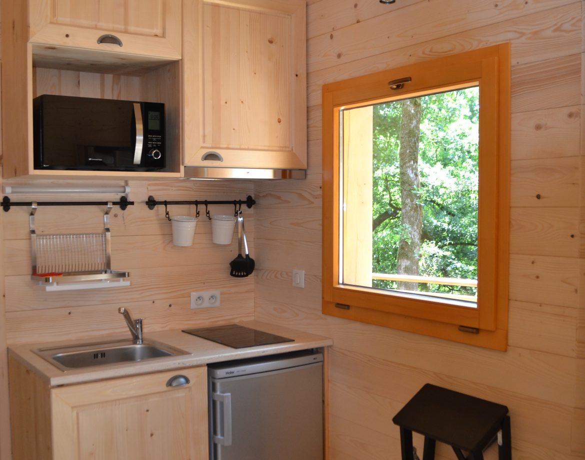 Cabane en bois à Nouvelle-Aquitaine, avec cuisine équipée et fenêtre lumineuse.