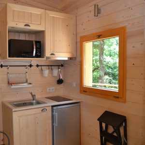 Cabane en bois à Nouvelle-Aquitaine, avec cuisine équipée et fenêtre lumineuse.