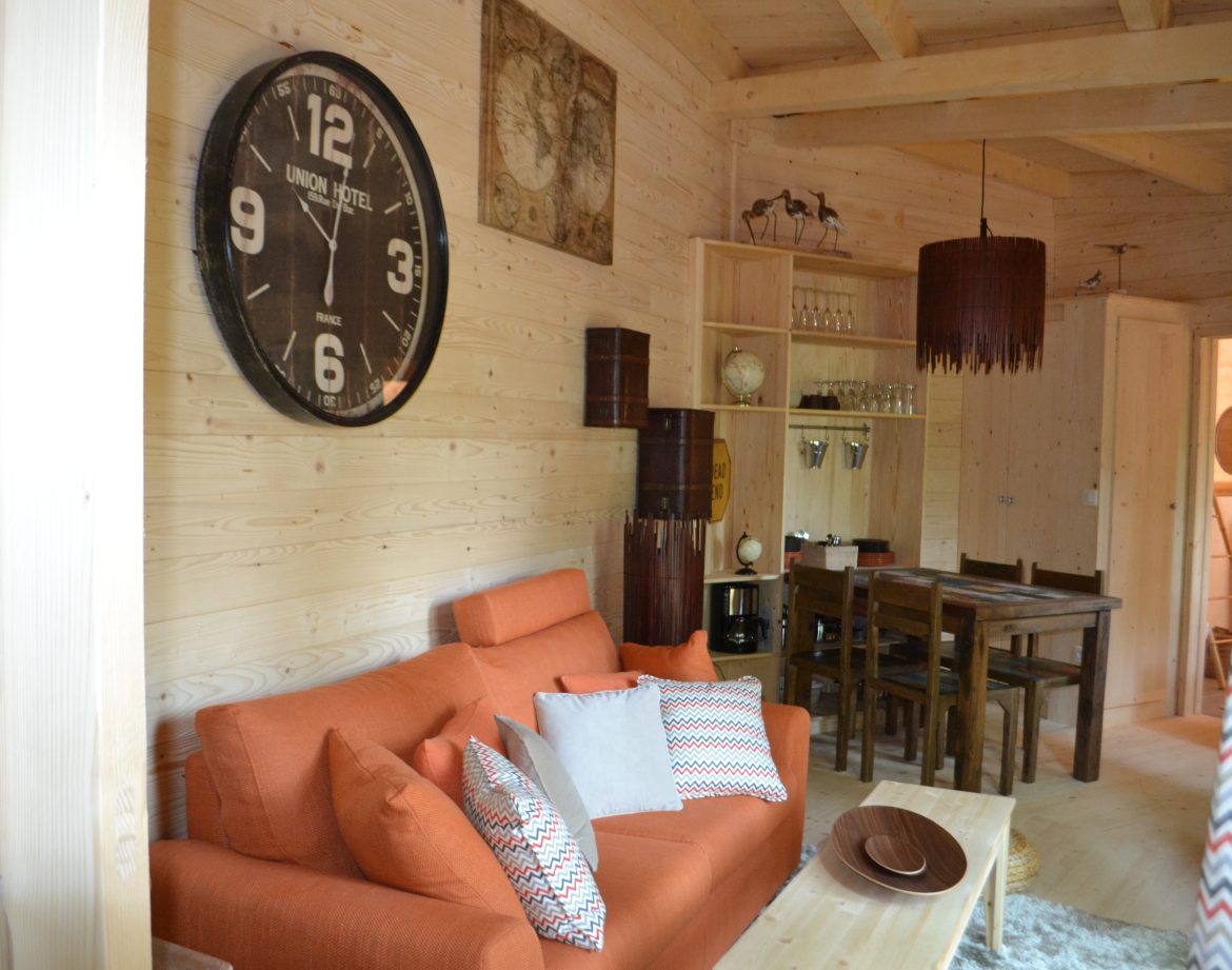 Hébergement insolite en Nouvelle-Aquitaine : chalet en bois avec un salon chaleureux et coloré.