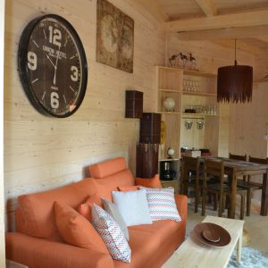 Hébergement insolite en Nouvelle-Aquitaine : chalet en bois avec un salon chaleureux et coloré.