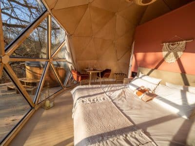Dôme géodésique en Auvergne, intérieur lumineux avec vue sur la nature et baignoire extérieure.