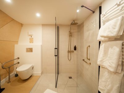 Salle de bain moderne dans un hébergement insolite en Auvergne, avec douche vitrée.