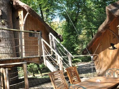 Cabane dans les arbres en Nouvelle-Aquitaine, entourée de verdure et de bois.