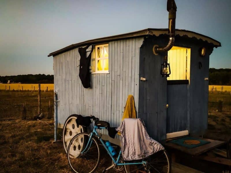 Charmante roulotte bleue avec une lumière chaleureuse, idéale pour un séjour insolite.