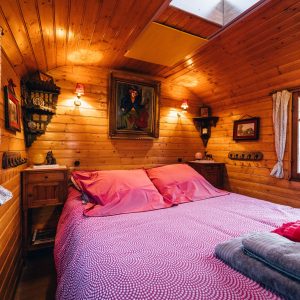 Chalet en bois chaleureux avec lit double et décoration rustique.