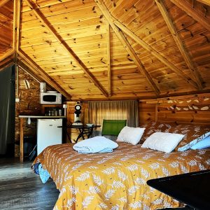Cabane en bois avec un lit douillet et un plafond en bois chaleureux.