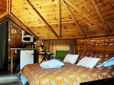 Cabane en bois avec un lit douillet et un plafond en bois chaleureux.