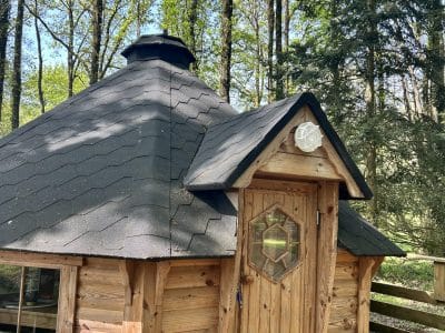 Cabane en bois ronde, nichée dans la forêt verdoyante des Pays de la Loire.