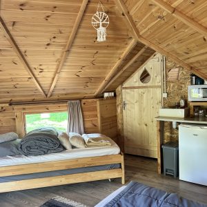 Cabane en bois cosy avec lit douillet et décoration naturelle.
