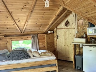 Cabane en bois cosy avec lit douillet et décoration naturelle.