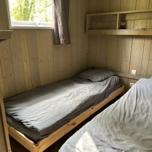 Chalet en bois cosy avec lits simples et lumière naturelle à Pays de la Loire.