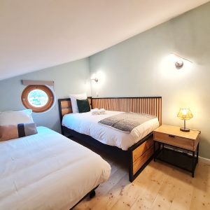 Chambre dhôtes atypique avec fenêtre ronde et décoration moderne en Bourgogne-Franche-Comté.