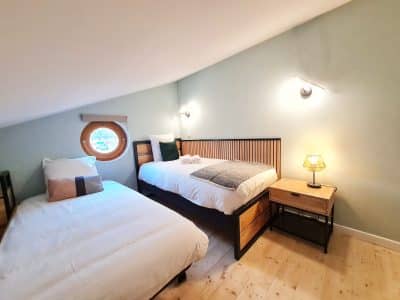 Chambre dhôtes atypique avec fenêtre ronde et décoration moderne en Bourgogne-Franche-Comté.