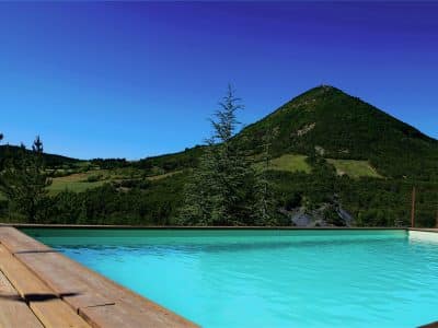 Hébergement insolite avec piscine, vue imprenable sur les montagnes verdoyantes.