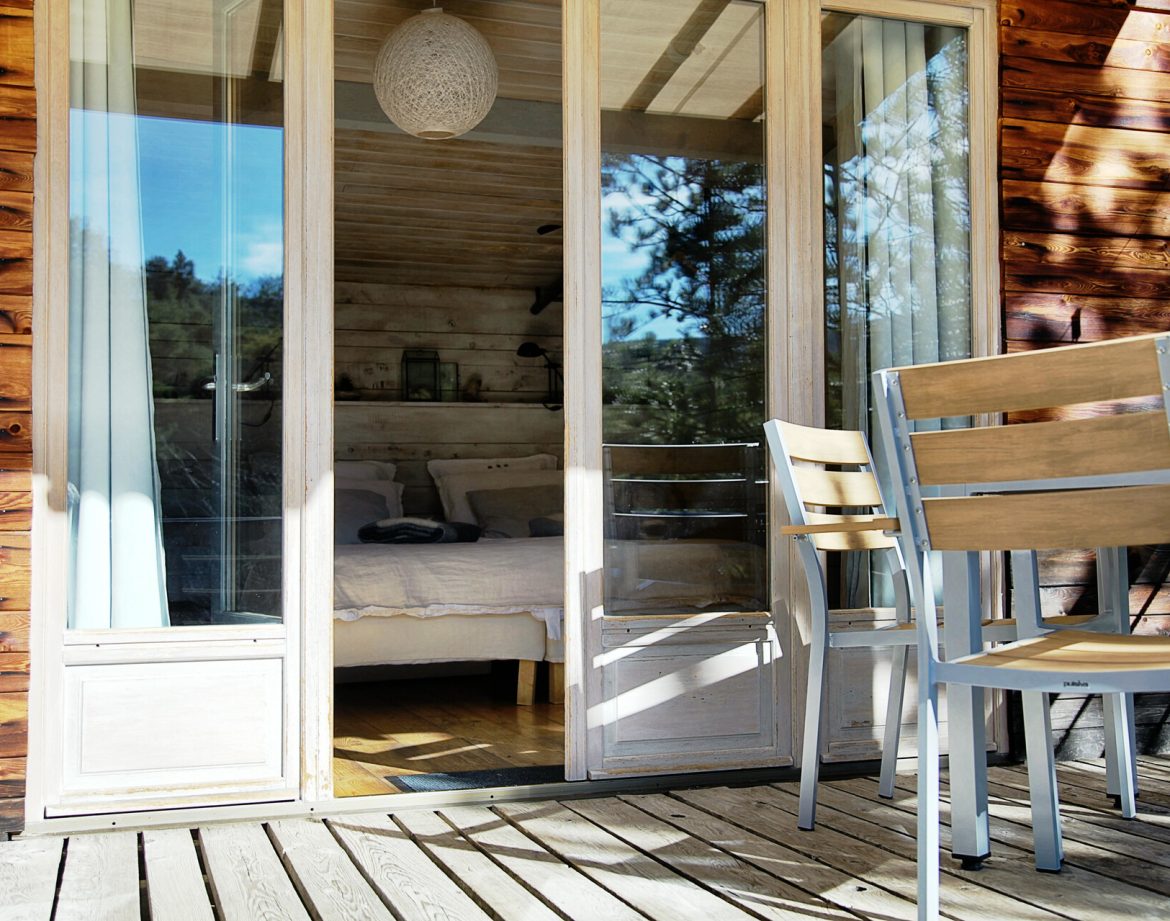 Cabane en bois avec terrasse, baignée de lumière naturelle à Provence-Alpes-Côte dAzur.
