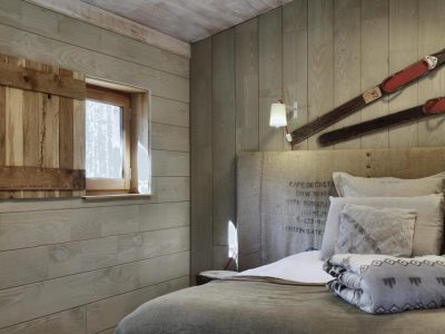 Chalet en bois avec un lit douillet et des décorations en bois rustiques.