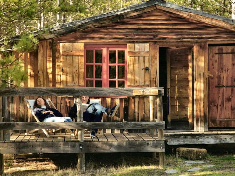 Cabane en bois dans la nature, avec une terrasse accueillante pour se détendre.