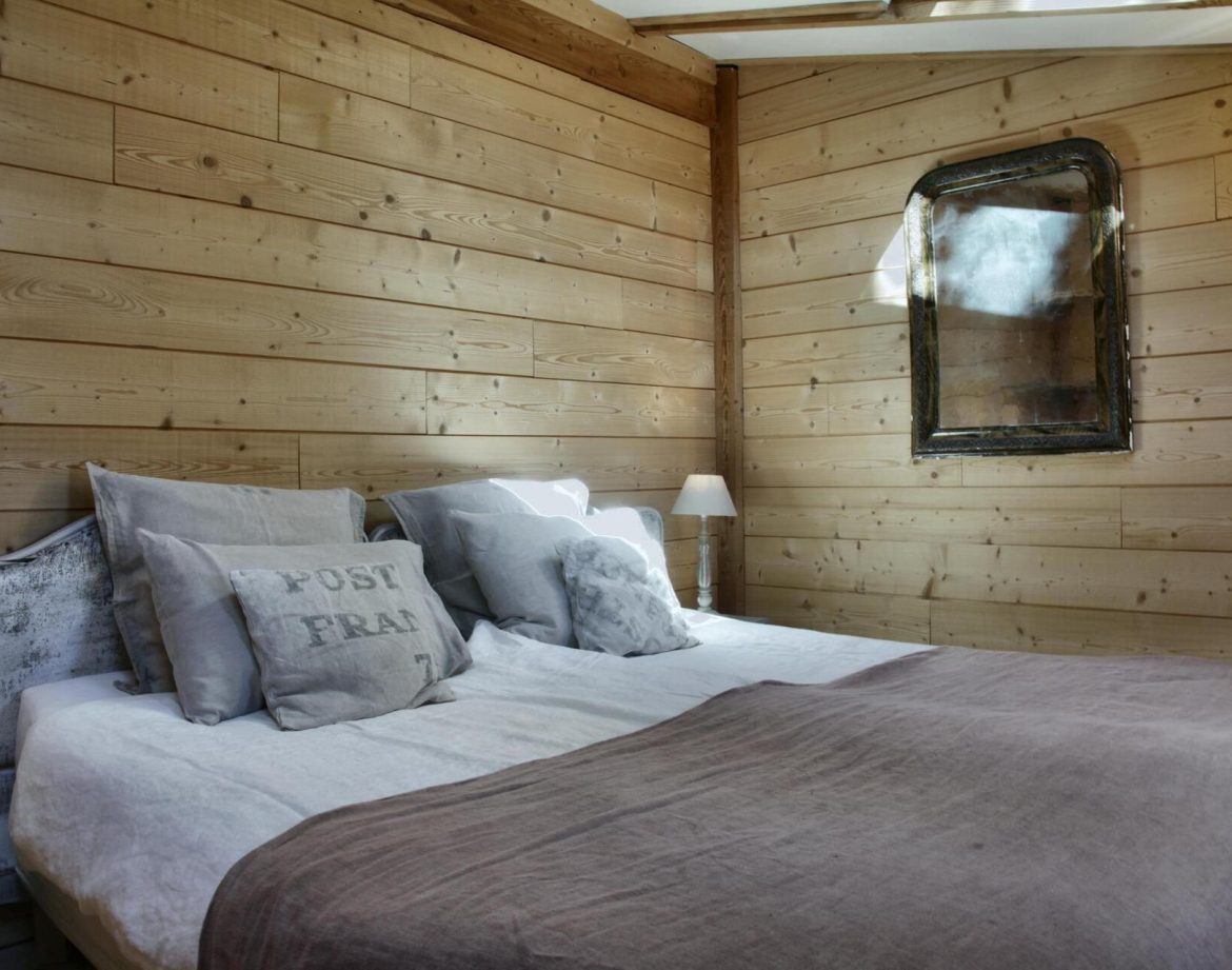 Chalet en bois chaleureux avec lit douillet et décor rustique en Provence-Alpes-Côte dAzur.