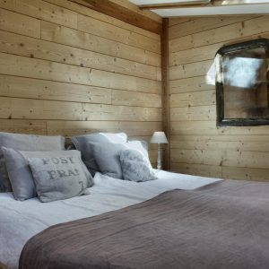 Chalet en bois chaleureux avec lit douillet et décor rustique en Provence-Alpes-Côte dAzur.