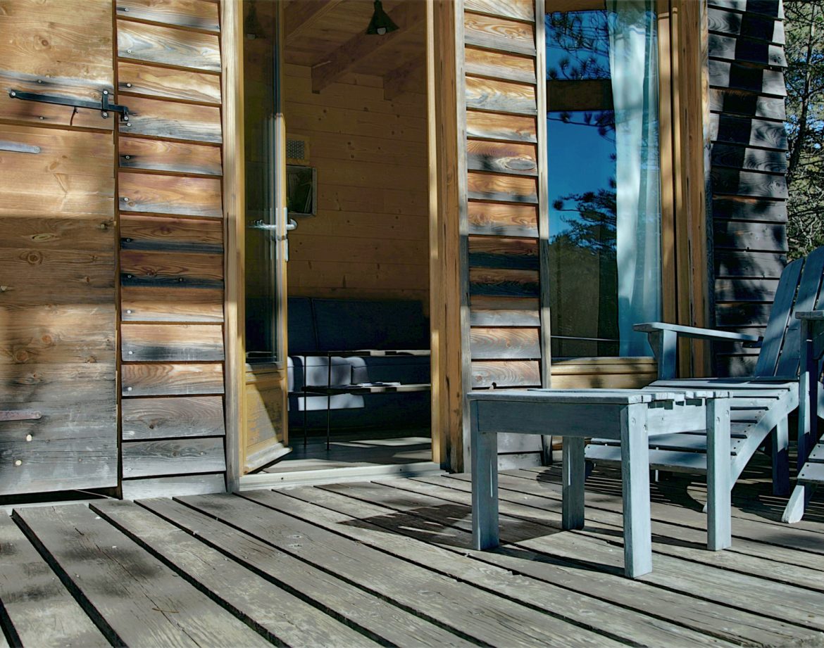 Cabane en bois avec chaises sur une terrasse ensoleillée en Provence-Alpes-Côte dAzur.