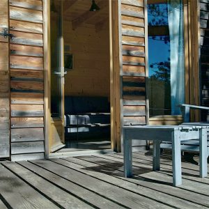 Cabane en bois avec chaises sur une terrasse ensoleillée en Provence-Alpes-Côte dAzur.
