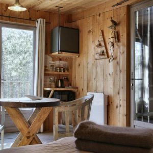 Cabane en bois dans les Alpes, avec un intérieur chaleureux et lumineux.