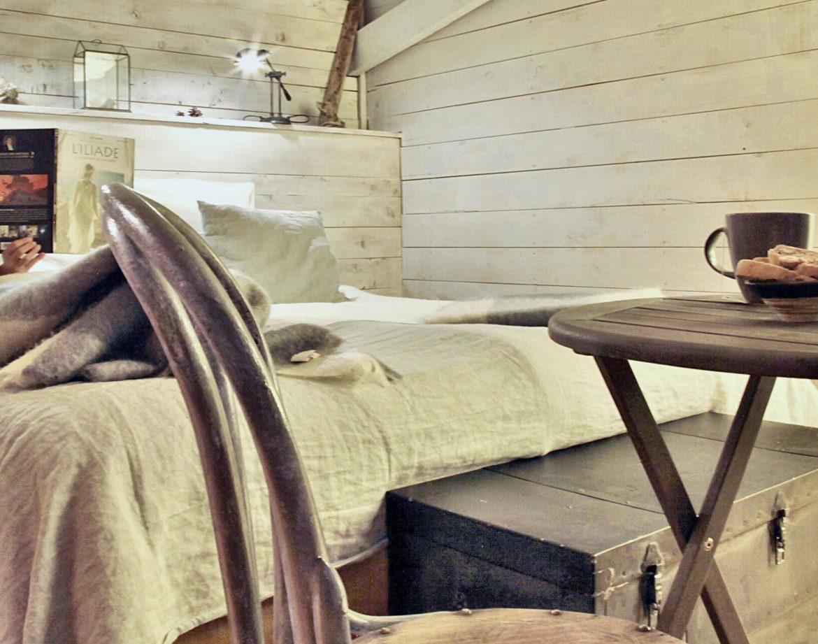 Chalet cosy en bois, lit douillet et table avec café et biscuits en Provence-Alpes-Côte dAzur.