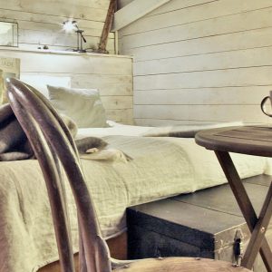 Chalet cosy en bois, lit douillet et table avec café et biscuits en Provence-Alpes-Côte dAzur.