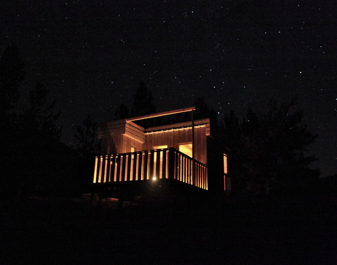 Cabane en bois éclairée sous un ciel étoilé en Provence-Alpes-Côte dAzur.